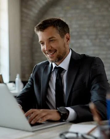 Developer in a suit working on a laptop