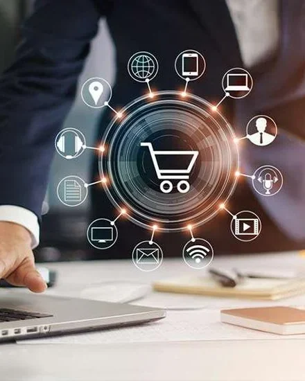 Shopping cart icon surrounded by online-store icons above a laptop